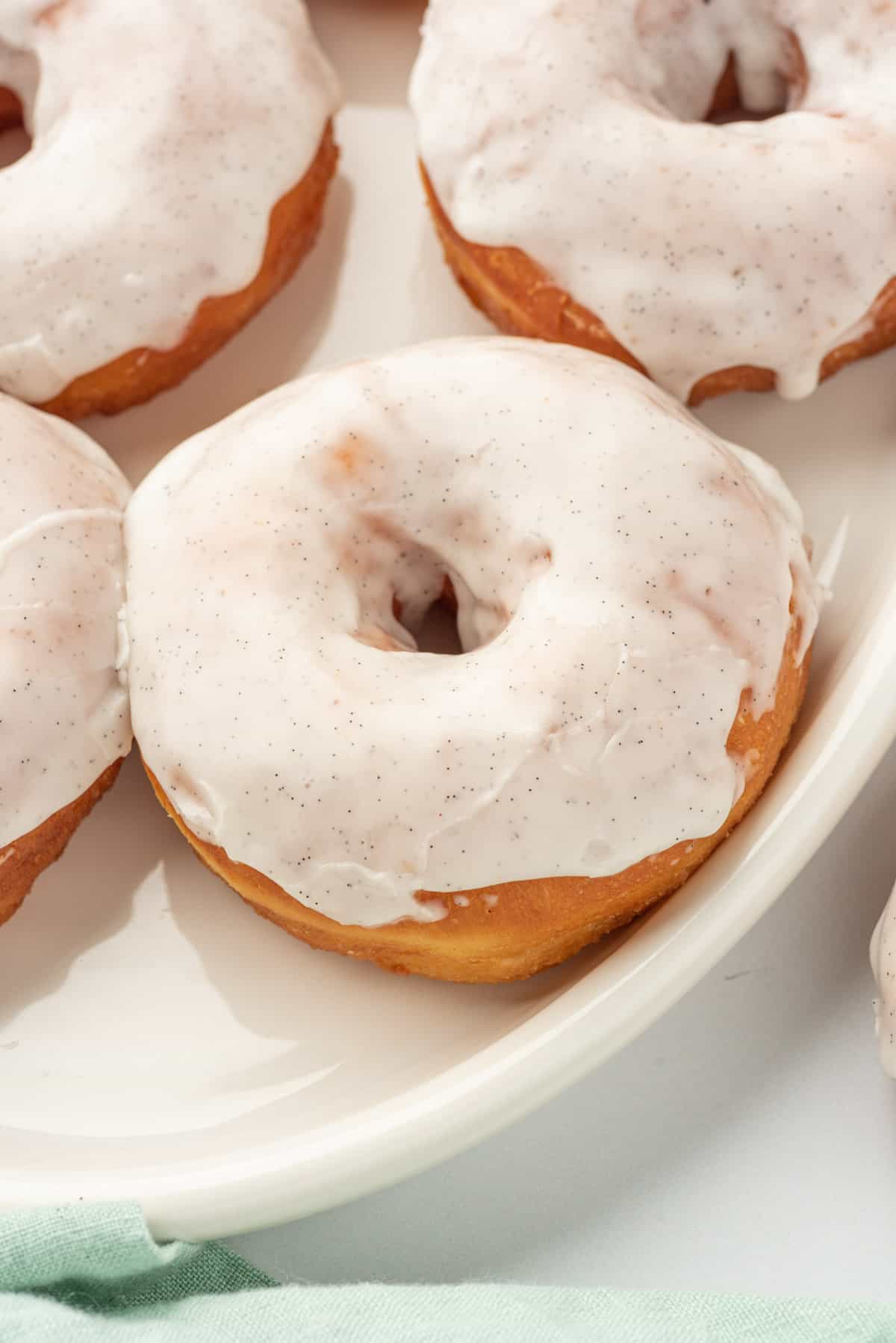 Several glazed donuts are placed on a white plate.