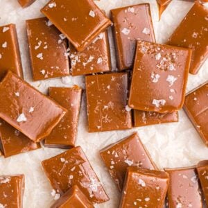 Several salted caramels are spread out across a white surface.