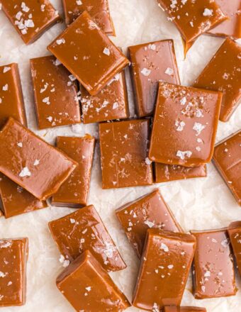 Several salted caramels are spread out across a white surface.