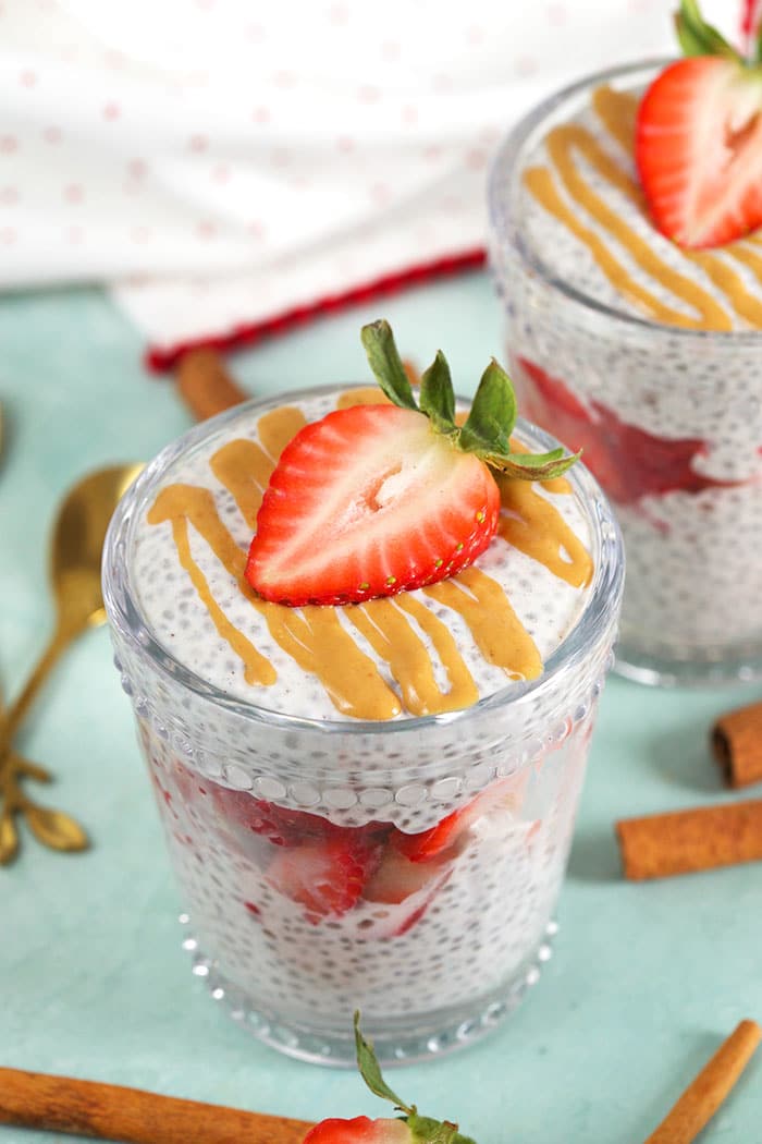 chia pudding in a glass with cinnamon sticks around it.