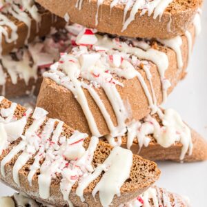 A stack of gingerbread biscotti is stacked on a white plate.