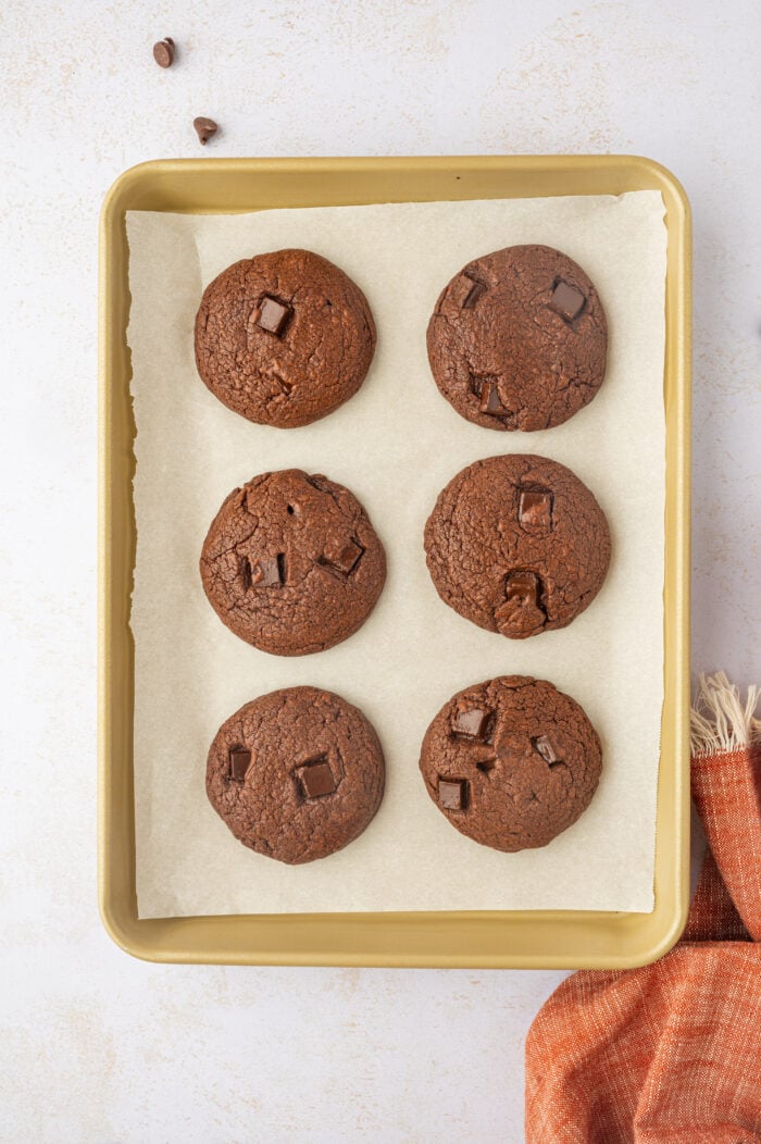 Overhead view of double chocolate chip cookies on parchment-lined baking sheet