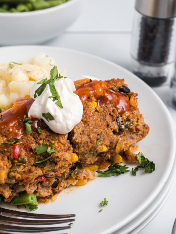 A white plate is topped with a serving of turkey meatloaf.