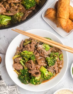 A shallow white bowl is filled with beef and broccoli.