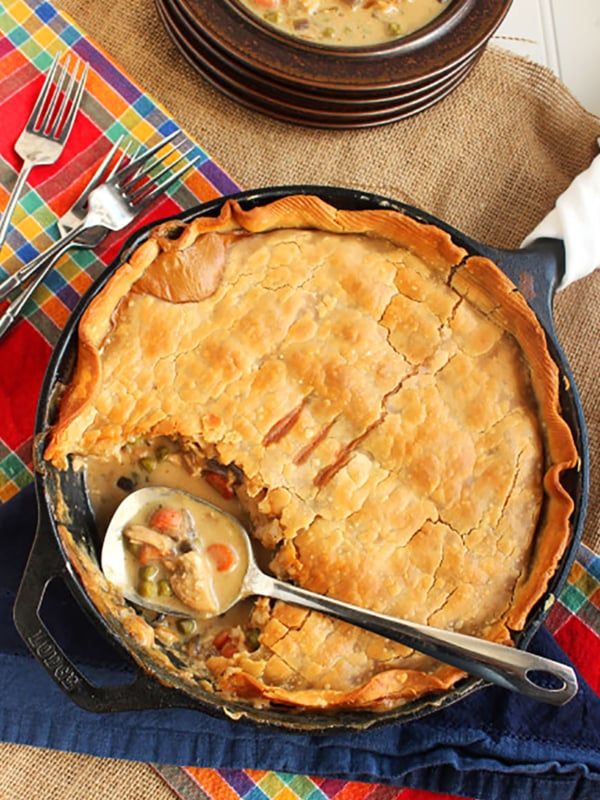 chicken pot pie in a cast iron skillet with a steel spoon.