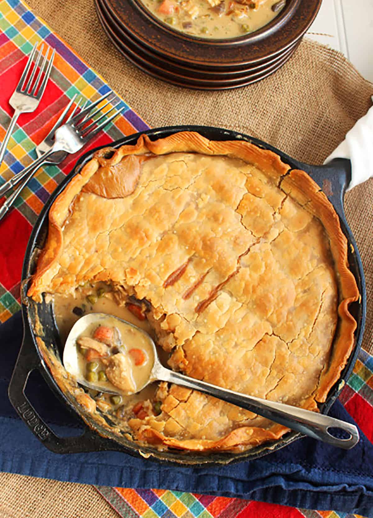 chicken pot pie in a cast iron skillet with a steel spoon.