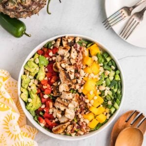 A large white bowl is filled with cobb salad.