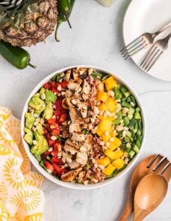 A large white bowl is filled with cobb salad.