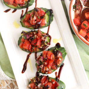 Platter with cucumber bruschetta drizzled with balsamic vinegar