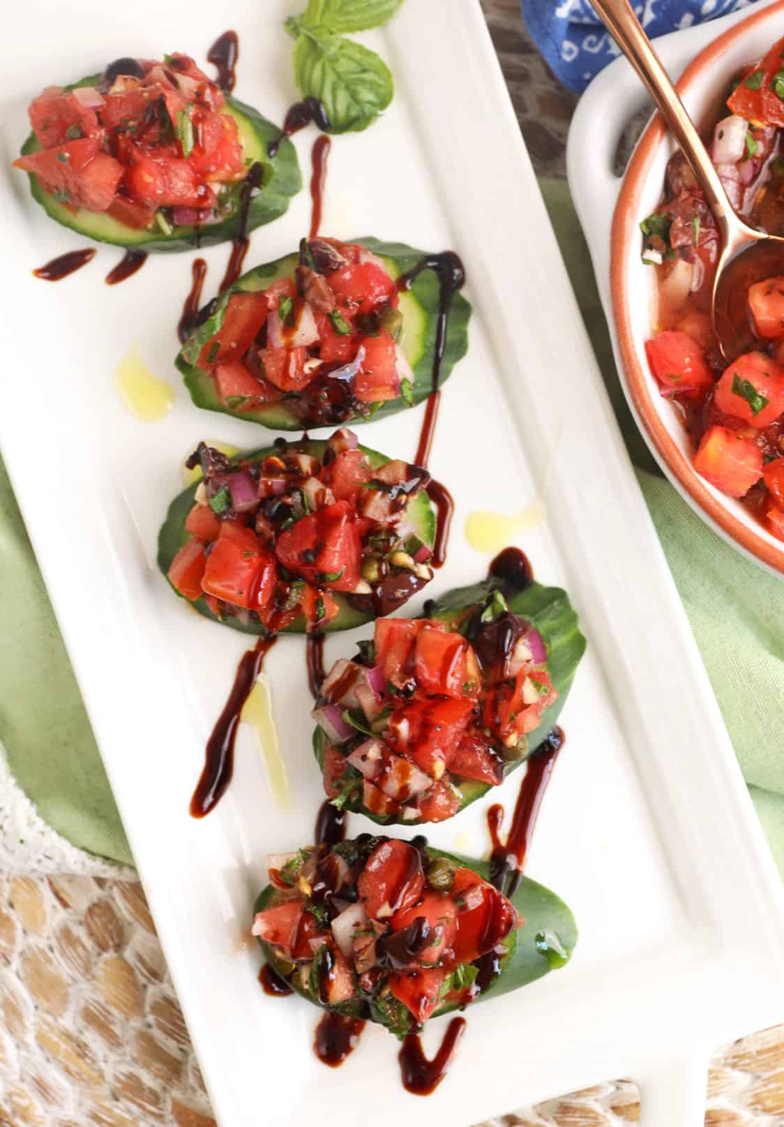 Platter with cucumber bruschetta drizzled with balsamic vinegar