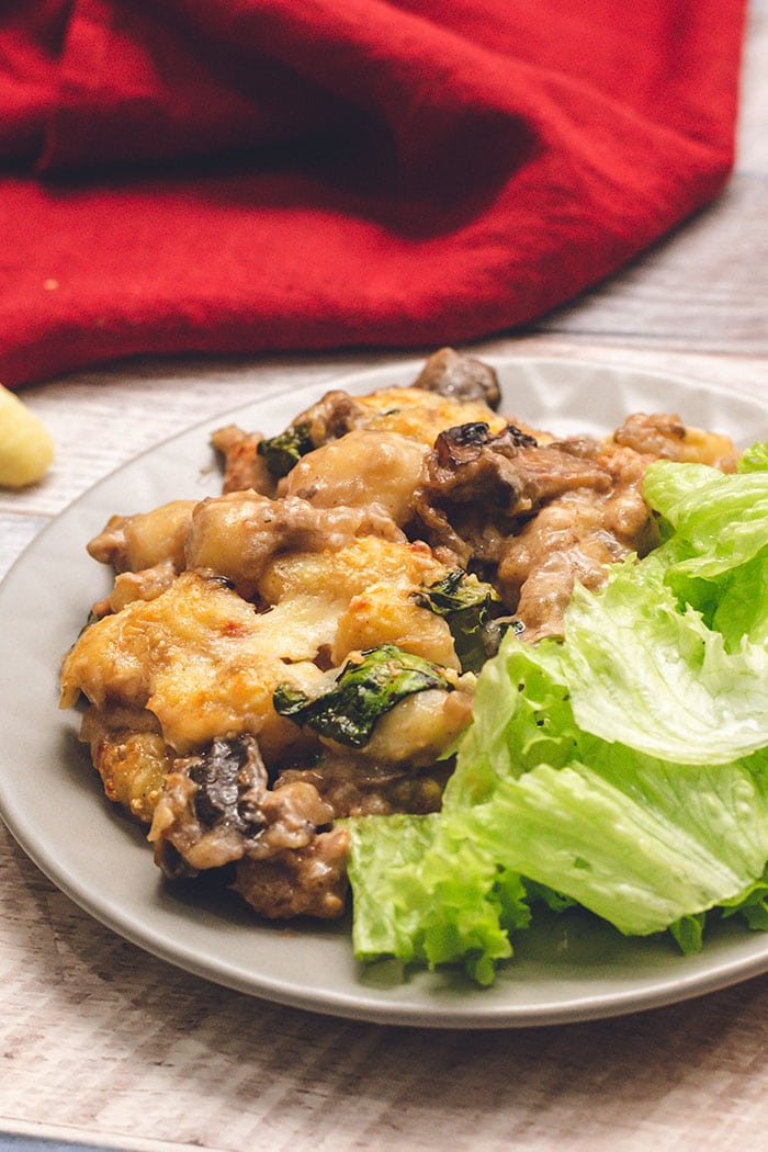 Baked gnocchi on a plate with a salad.