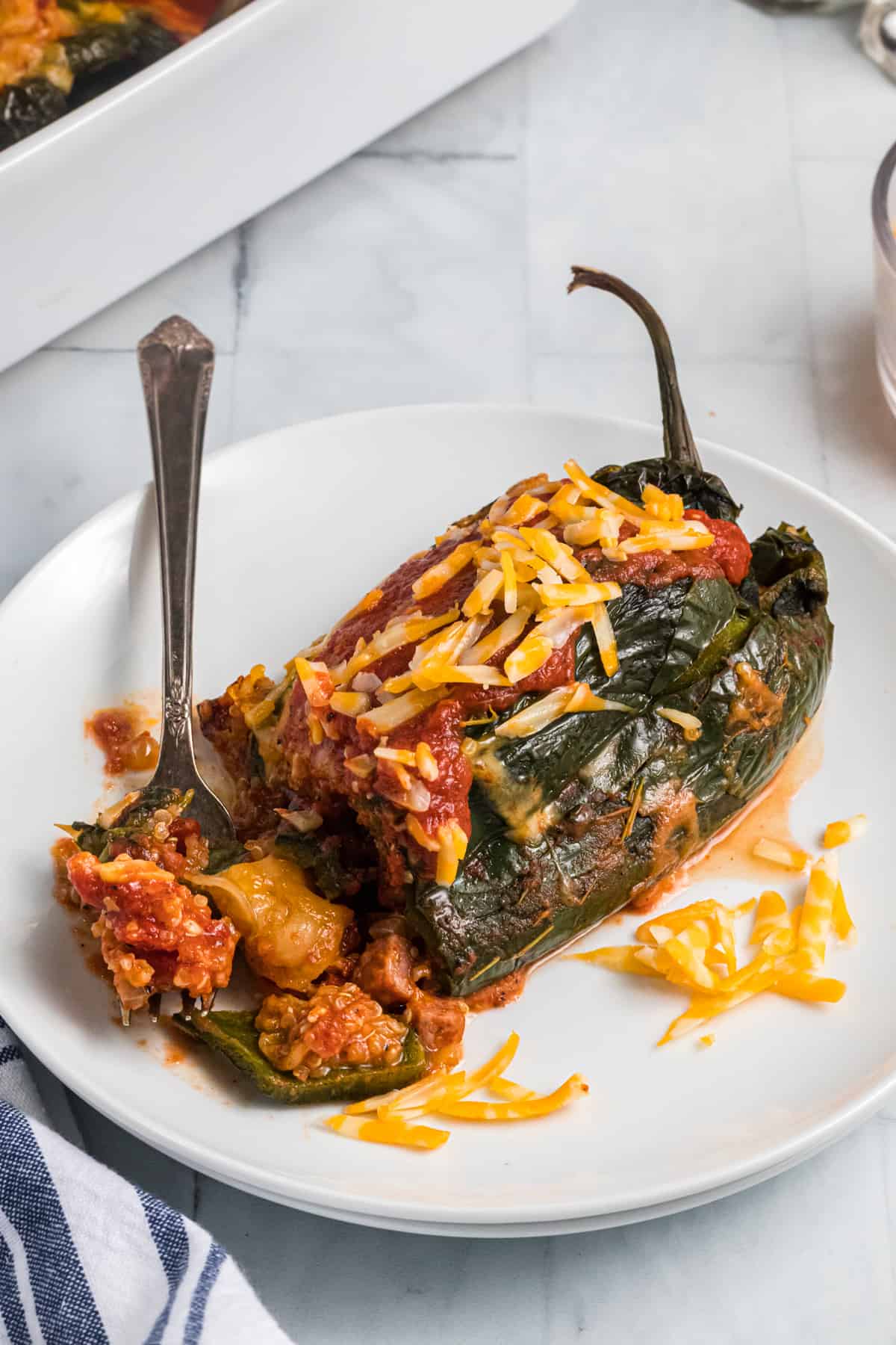 A cooked stuffed pepper is being dug into with a fork.