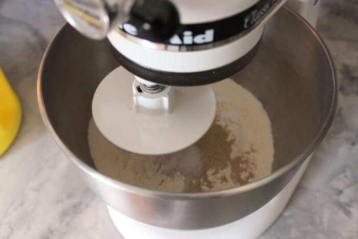 pizza dough ingredients in the bowl of a mixer