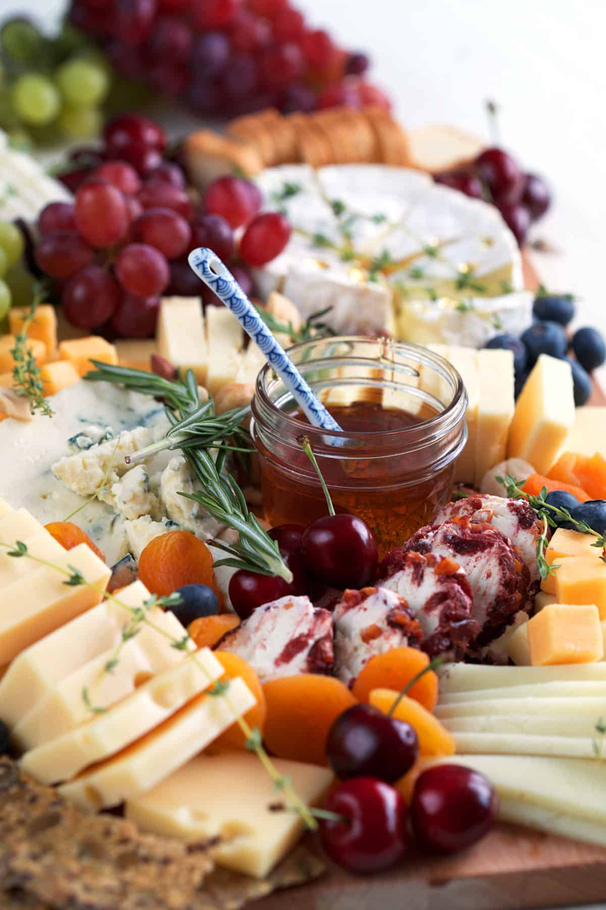 Cheese board with cheese, fruit, honey, etc.