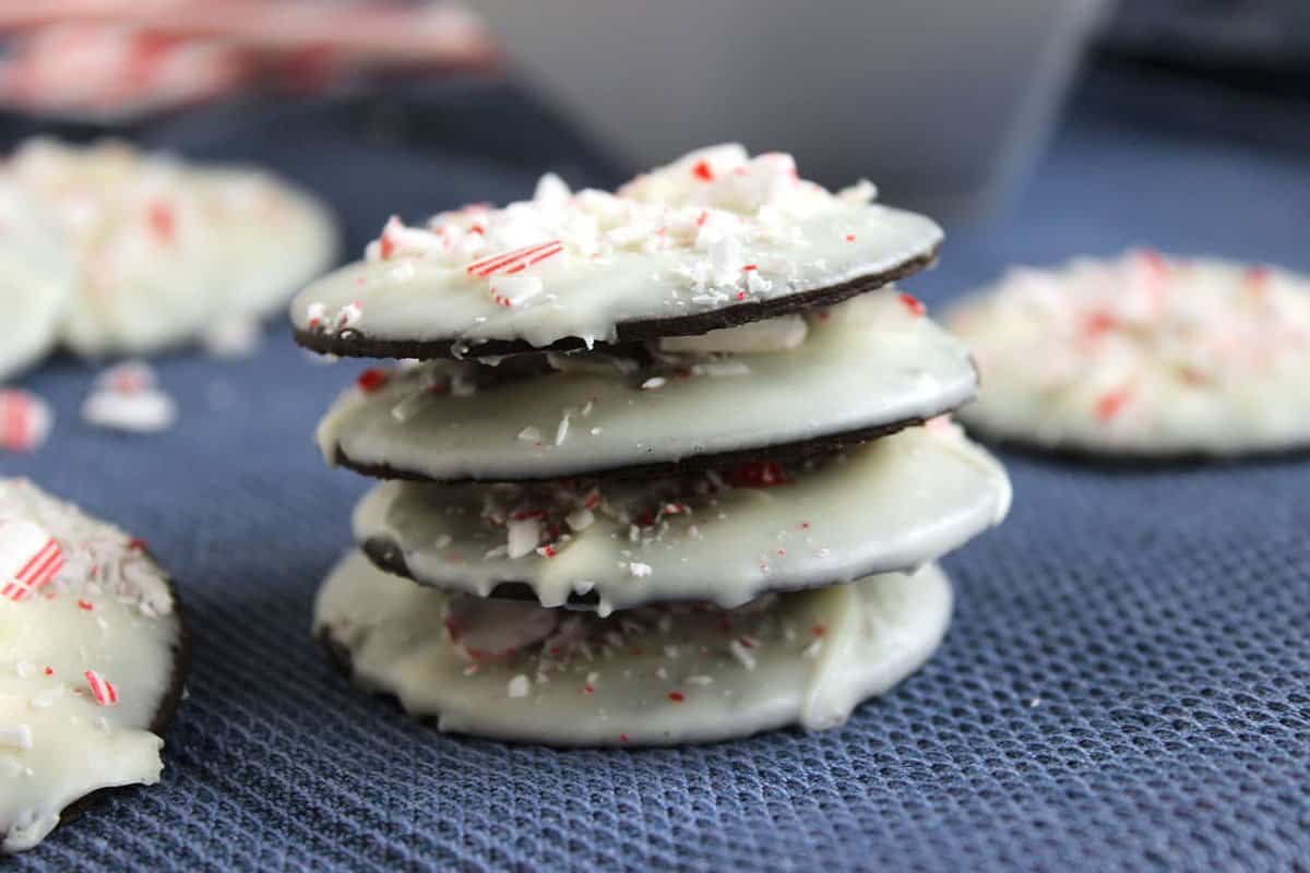 Image shows a stack of peppermint bark cookies on a blue placemat