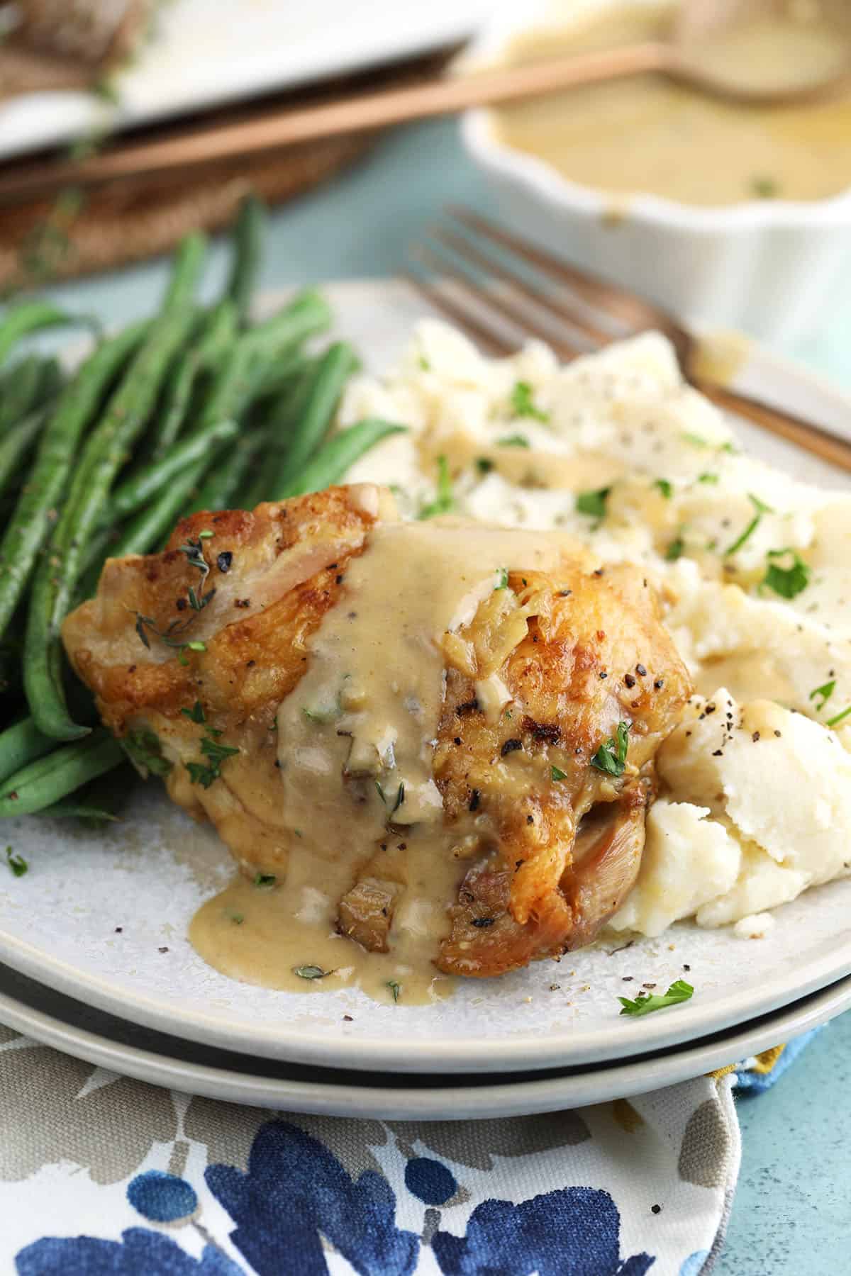 Braised Chicken Thighs on a plate with green beans.