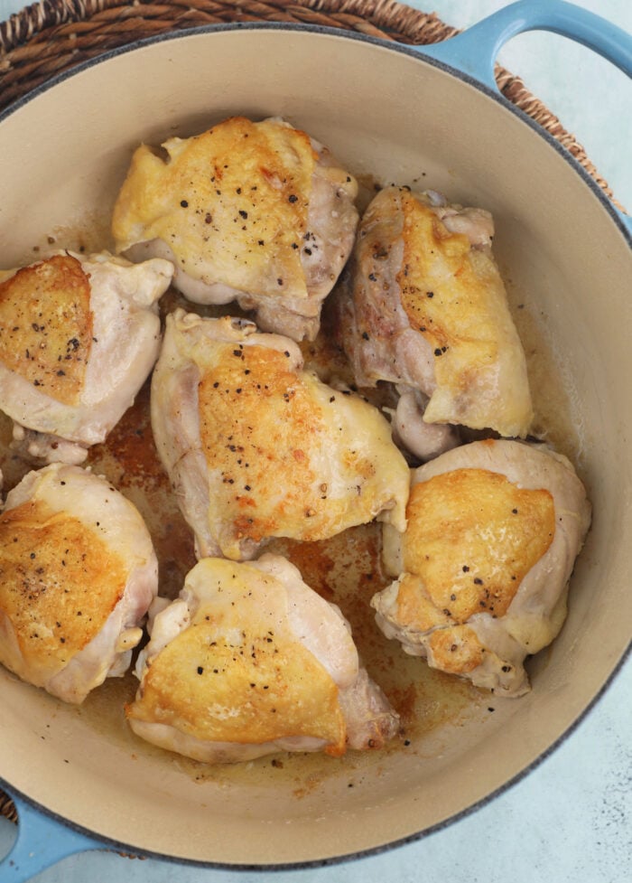 chicken thighs seared in a dutch oven.