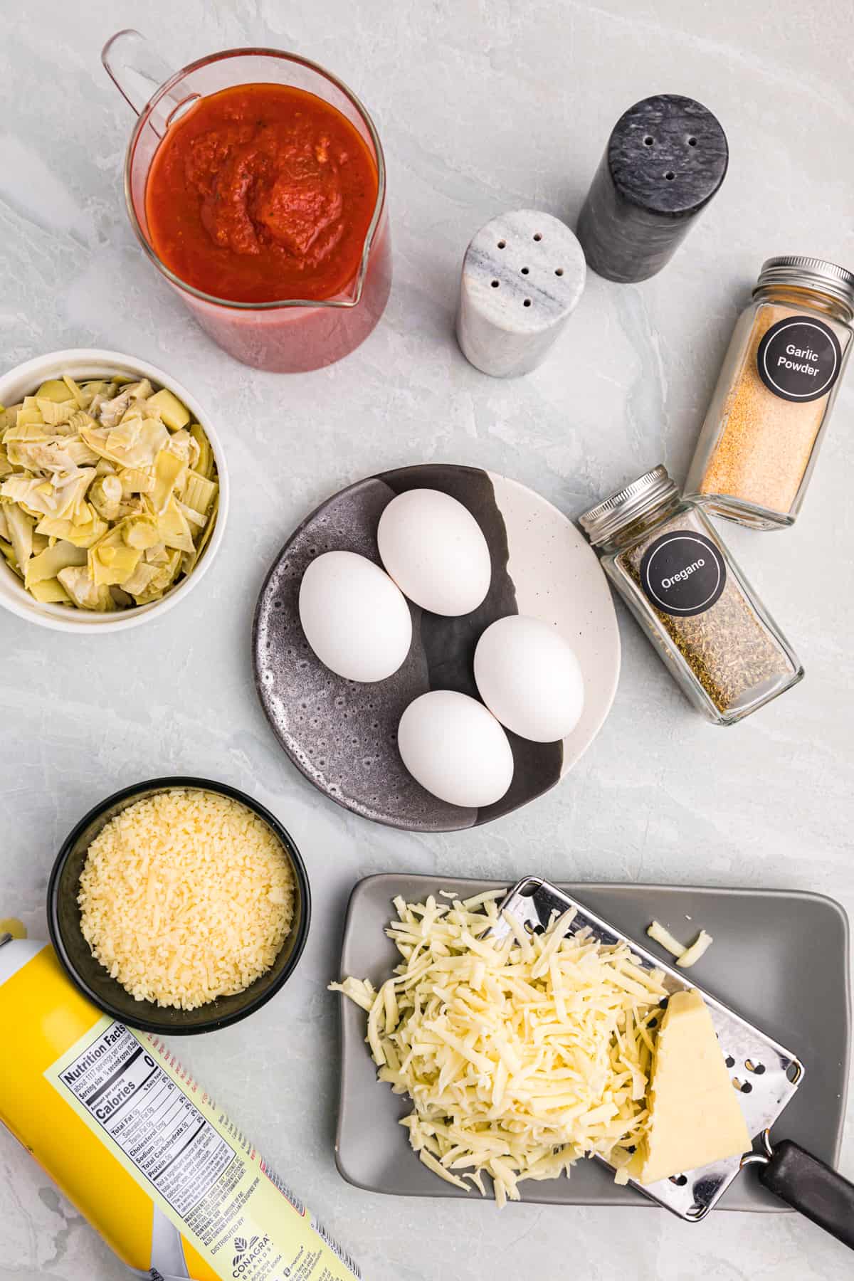 Ingredients for Italian Baked Eggs on a gray background.