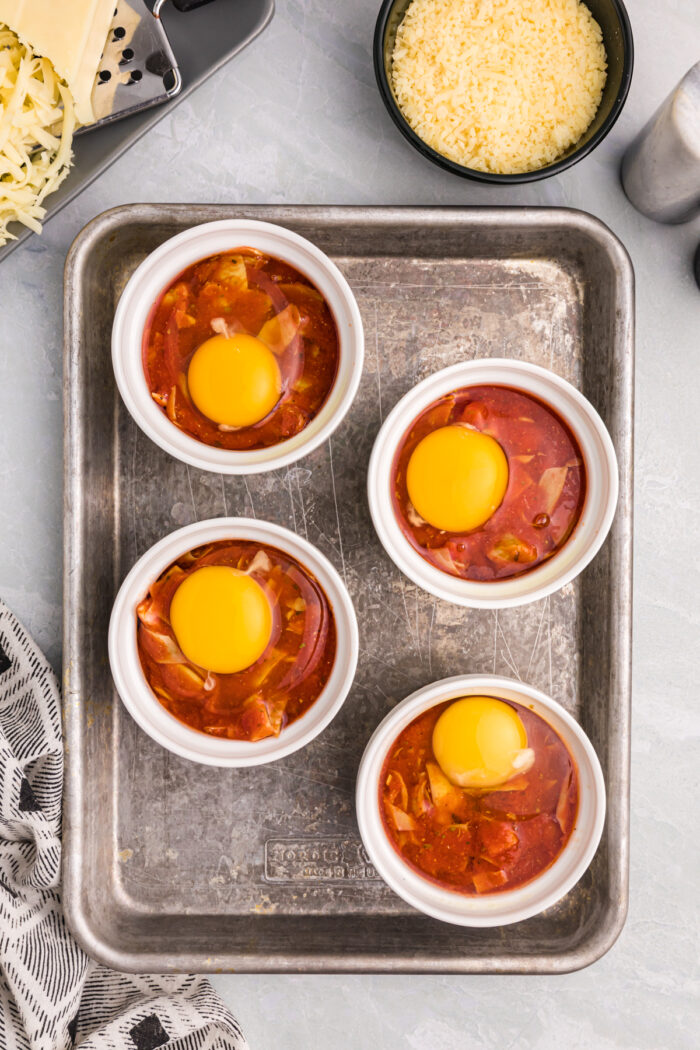 Eggs on top of tomato sauce prior to baking