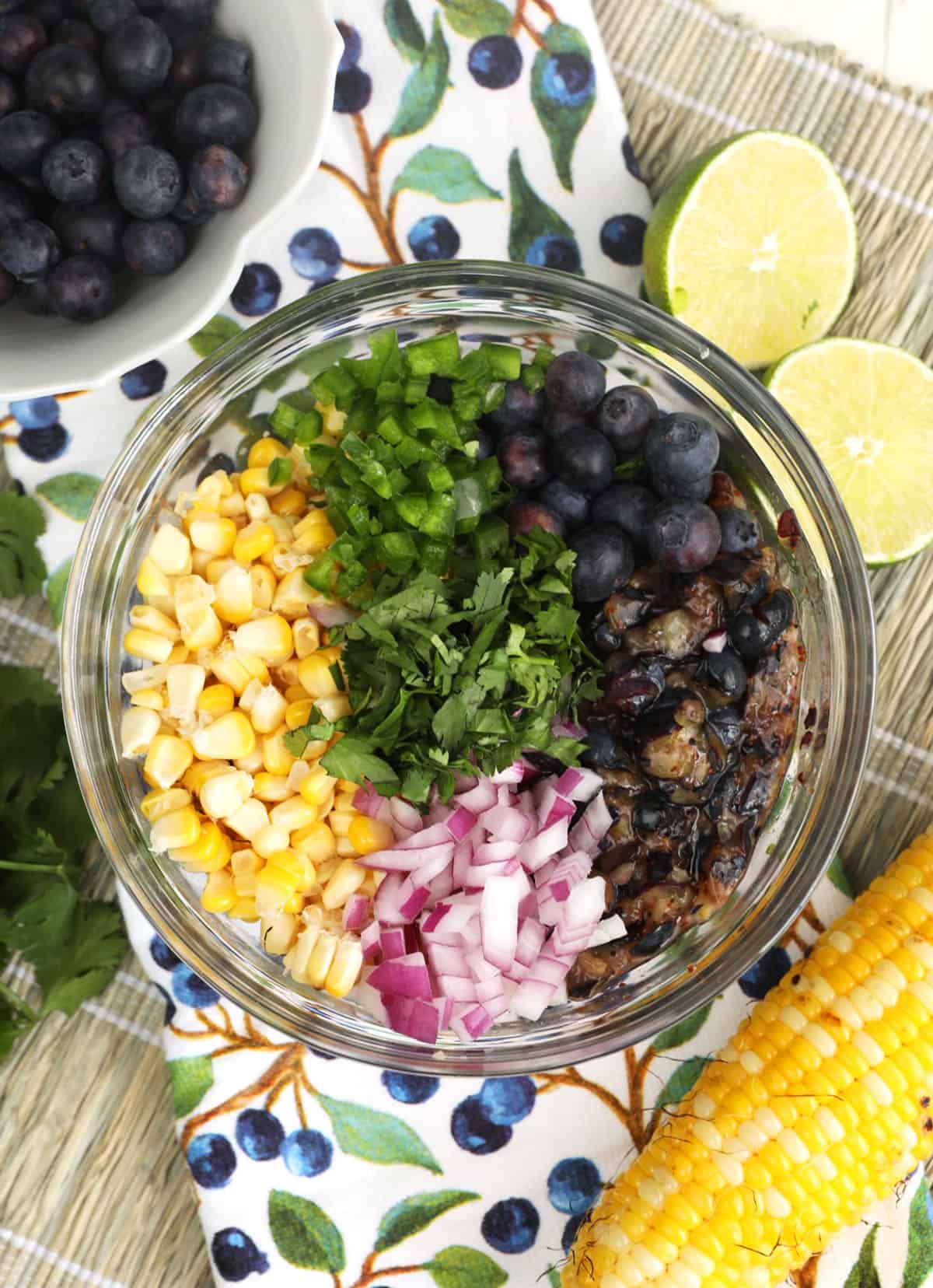 Overhead view of ingredients for blueberry corn salsa in mixing bowl