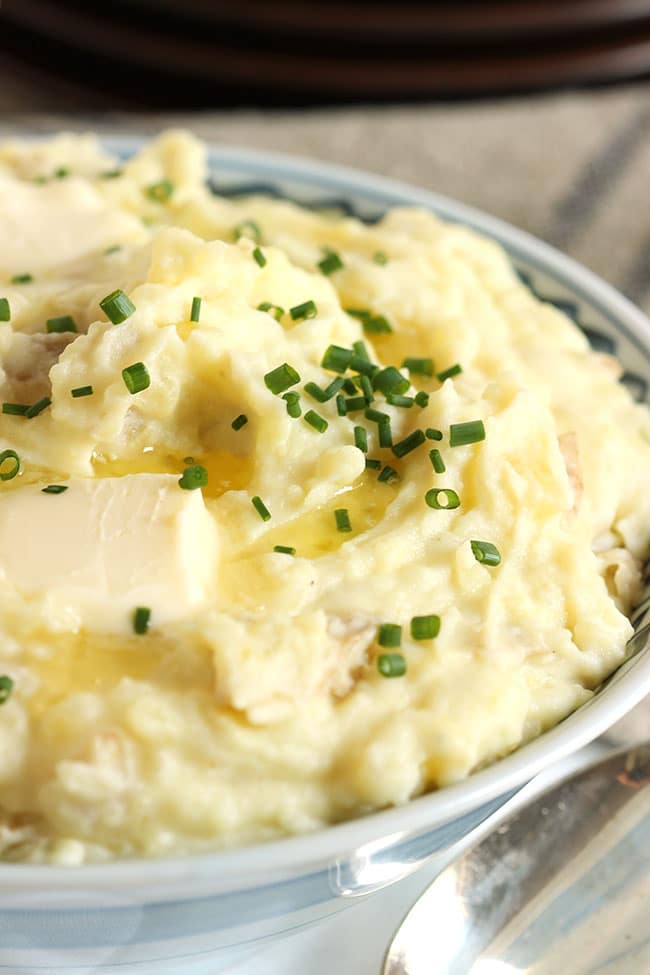 MASHED POTATOES WITH SNIPPED CHIVES AND BUTTER ON TOP.