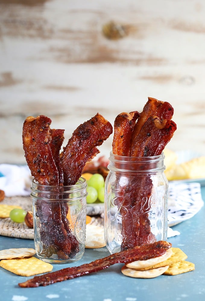 Sweet and spicy candied bacon in two mason jars.