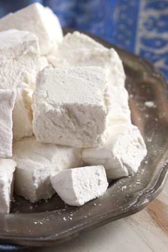 Pile of homemade marshmallows on a pewter plate.