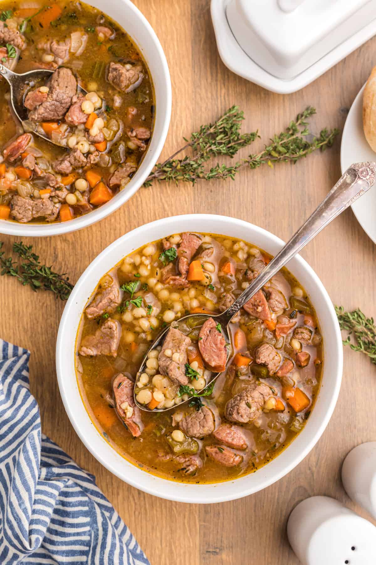 Two white bowls are crammed with soup.  Beef and Barley Soup with Andouille Sausage BeefBarleySoup 19
