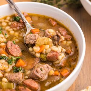 A spoon is digging right into a bowl chubby of soup.  Beef and Barley Soup with Andouille Sausage BeefBarleySoup 21 300x300