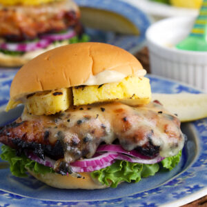 Grilled teriyaki chicken sandwich on plate with grilled pineapple and toppings