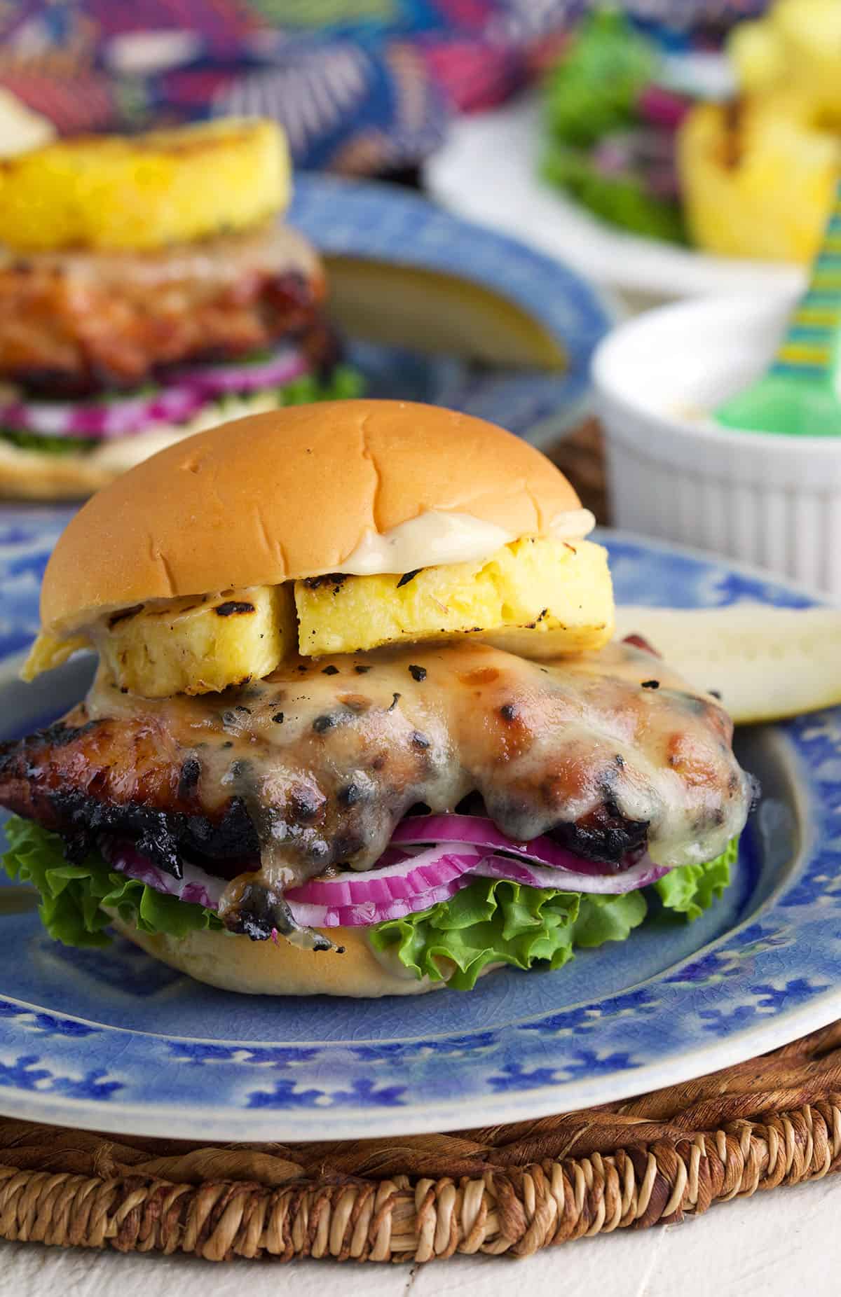 Grilled teriyaki chicken sandwich on plate with grilled pineapple and toppings