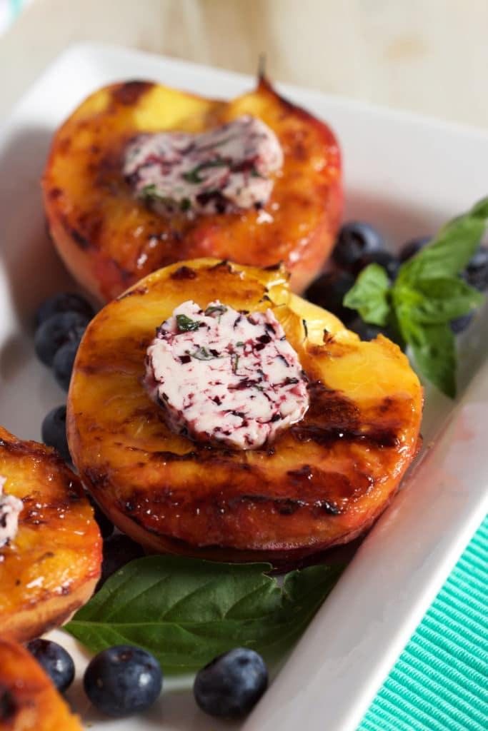 A quick and easy Grilled Peach recipe topped with an easy to make blueberry basil butter from TheSuburbanSoapbox.com.