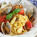 Linguine with clams in a white bowl with a silver fork.