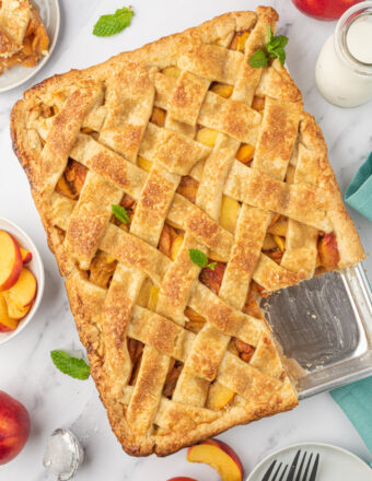 A peach slab pie has one piece missing.