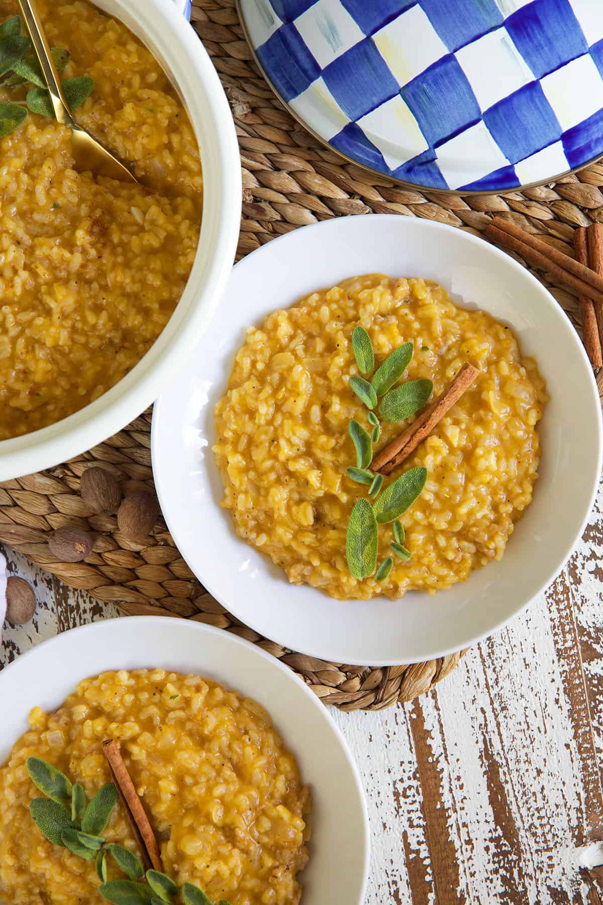 Two bowls of risotto are placed next to a large serving bowl.