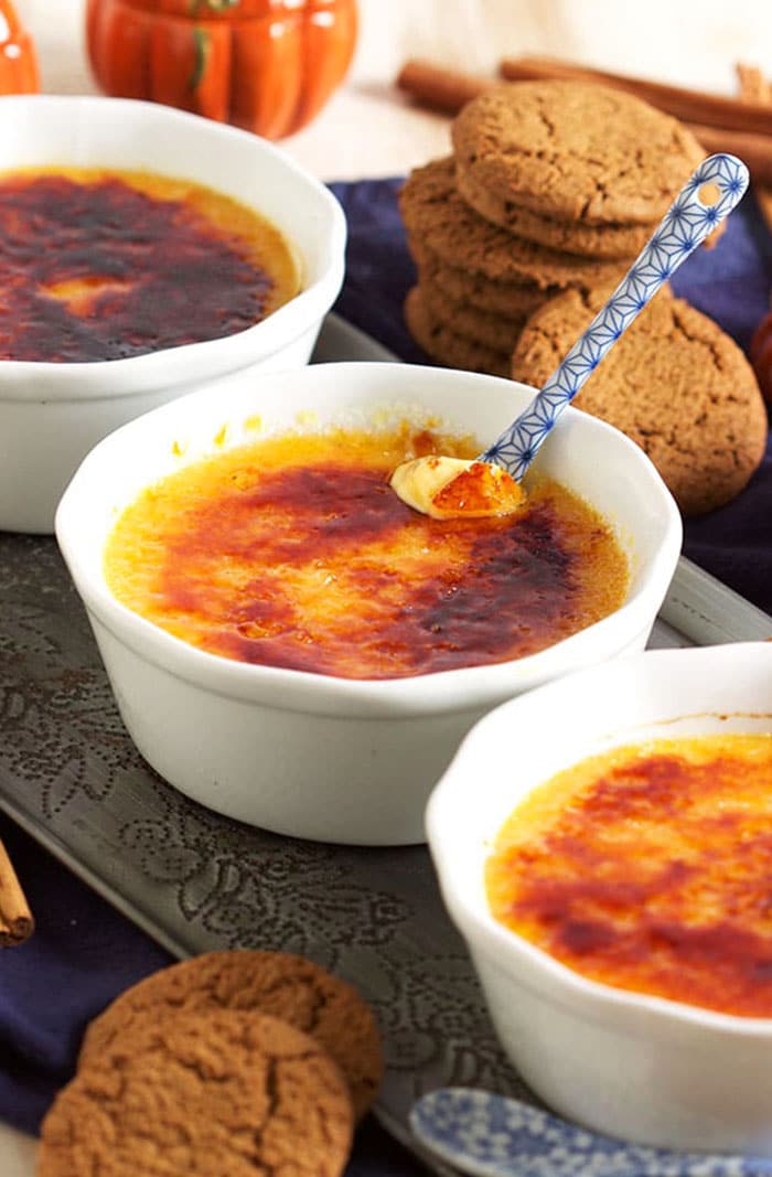 Pumpkin Creme Brulee in a white ramekin with a blue and white spoon.