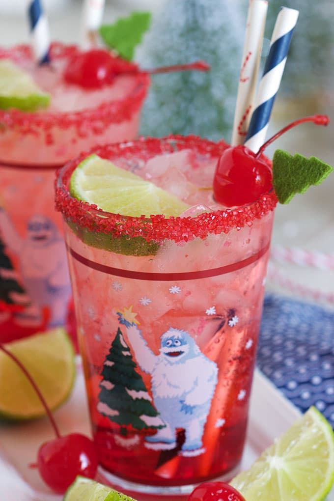 Shirley Temple drink in a Rudolph glass with red sugar rim and cherry on top.
