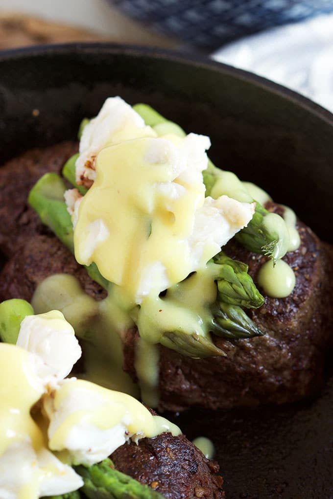 Filet Mignon with asparagus, crab and béarnaise in a cast iron skillet.