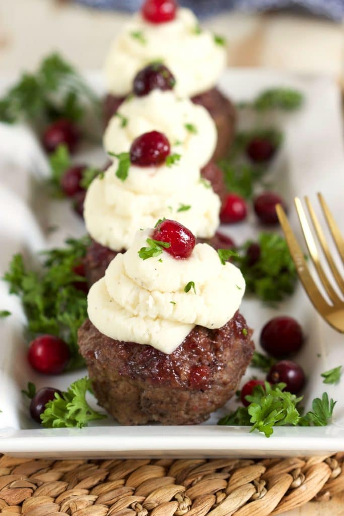 Super easy and ready in minutes, these simple Mini Meatloaf Cupcakes with Cranberry Glaze recipe is topped with your family's favorite leftover mashed potatoes! A great weeknight dinner! | TheSuburbanSoapbox.com