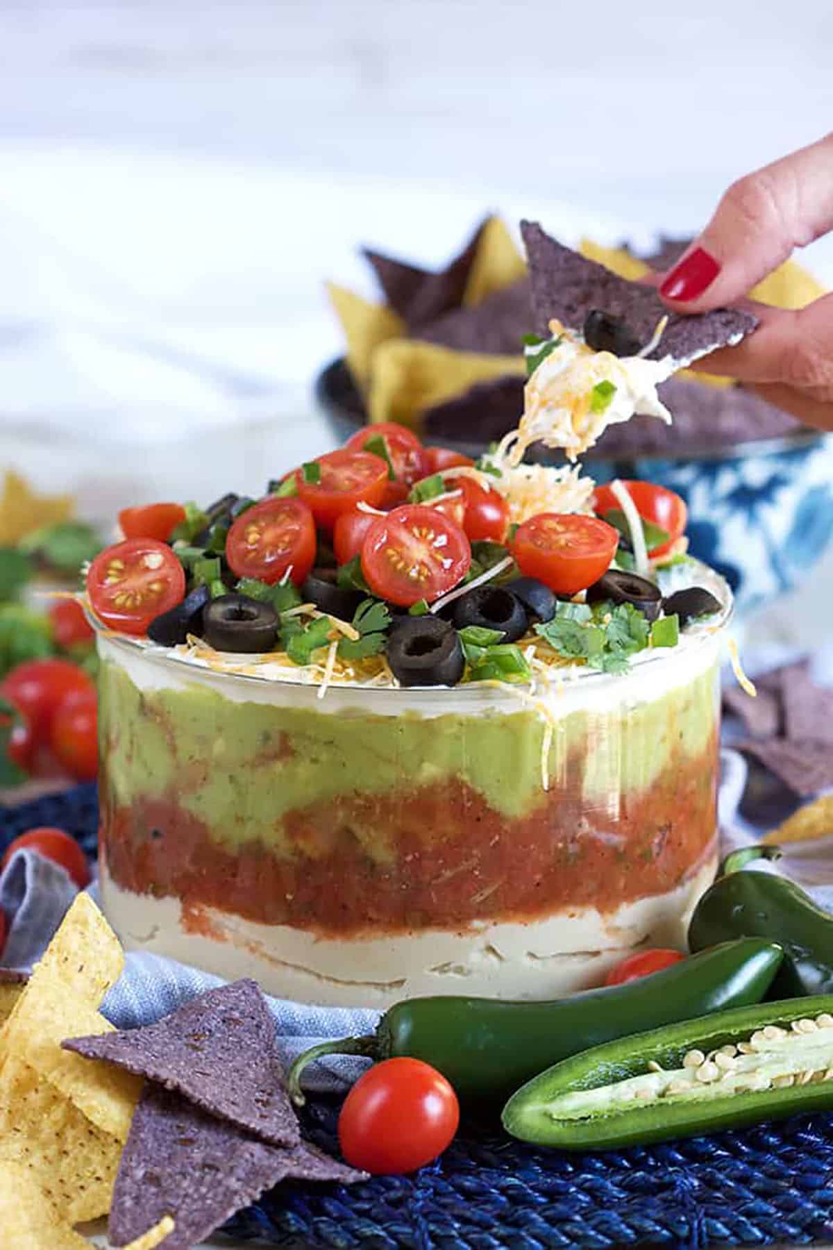 7 layer mexican dip with a chip being dipped into the top.