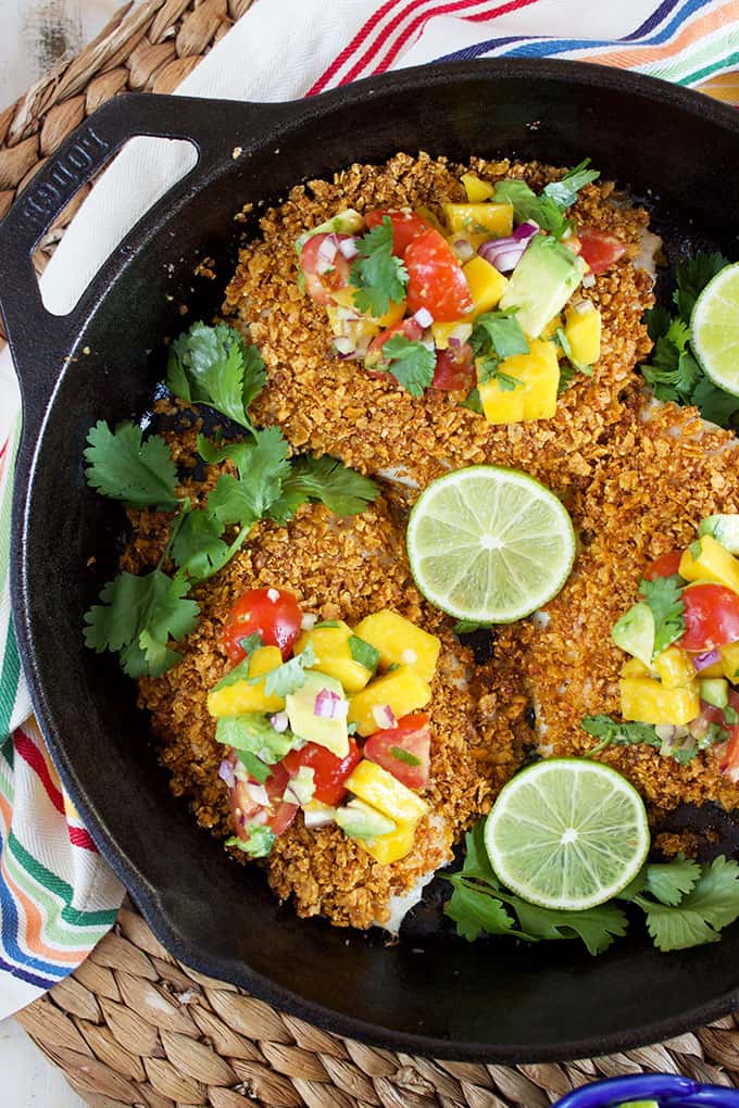 Ready in just 20 minutes, this easy Tortilla Crusted Tilapia recipe is topped with a simple and refreshing Avocado Mango Salsa! | @suburbansoapbox TheSuburbanSoapbox.com