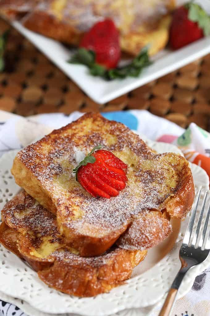 Two slices of French toast with a strawberry on a white plate from TheSuburbanSoapbox.com
