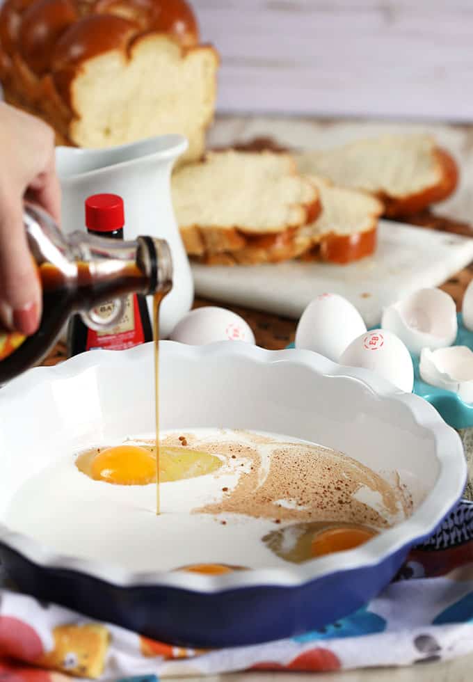 Adding maple syrup to the very best French toast recipe ingredients in a blue pie plate from TheSuburbanSoapbox.com
