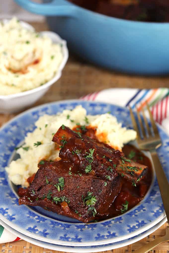 Honey Chipotle Braised Short Ribs and Mashed Potatoes on a blue plate with gold fork. Thesuburbansoapbox.com