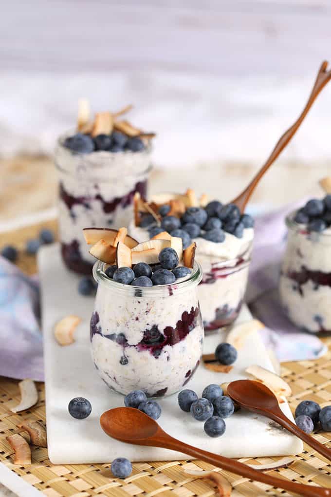 Blueberry Toasted Coconut Overnight Oats in jars with wooden spoons from TheSuburbanSoapbox.com