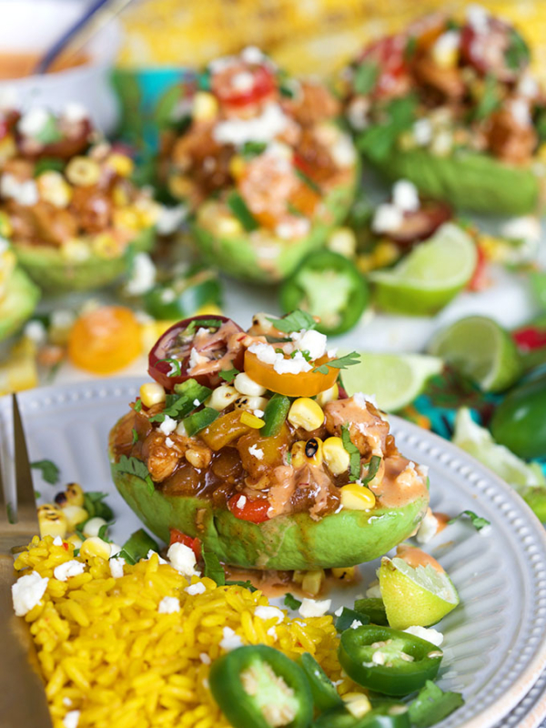 Chicken Fajita Stuffed Avocados on a white plate with Mexican saffron rice from TheSuburbanSoapbox.com