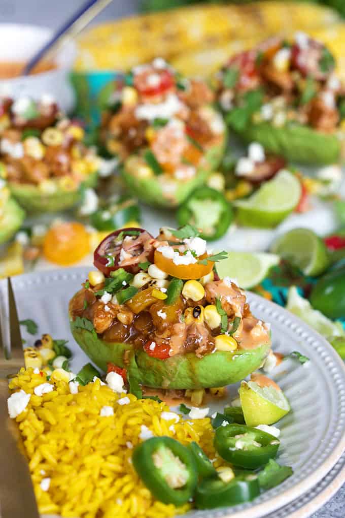 Chicken Fajita Stuffed Avocados on a white plate with Mexican saffron rice from TheSuburbanSoapbox.com