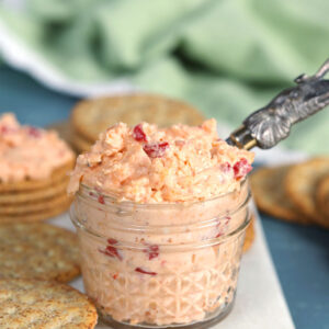 Pimento Cheese in a small jar with a spreader and green napkin from TheSuburbanSoapbox.com
