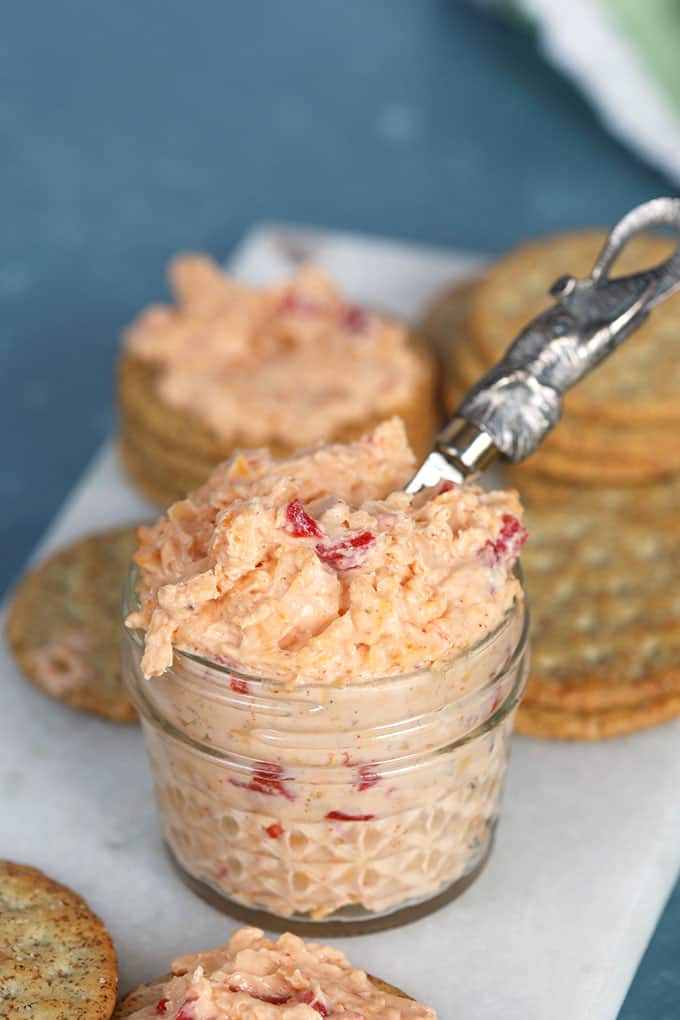 Pimento Cheese in a glass jar with a silver elephant spreader on a marble board from TheSuburbanSoapbox.com