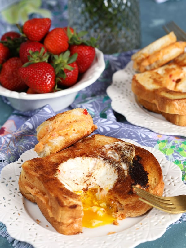 Egg in a Hole Pimento Grilled Cheese Sandwich on a white plate with a blue background from Thesuburbansoapbox.com